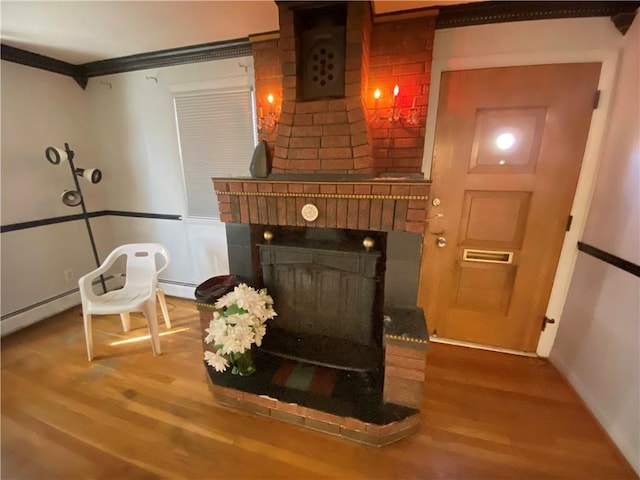 living room with a brick fireplace and wood finished floors