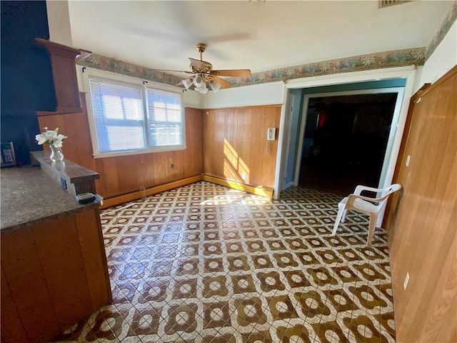 interior space with wooden walls and a ceiling fan