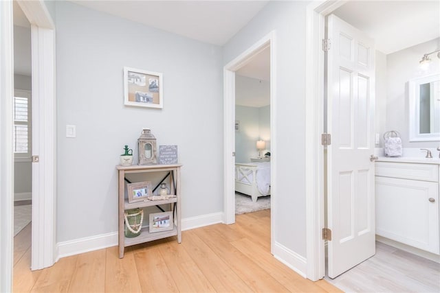 hallway with baseboards and light wood-type flooring