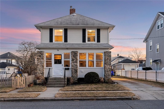 american foursquare style home featuring driveway, entry steps, fence, a shingled roof, and a chimney