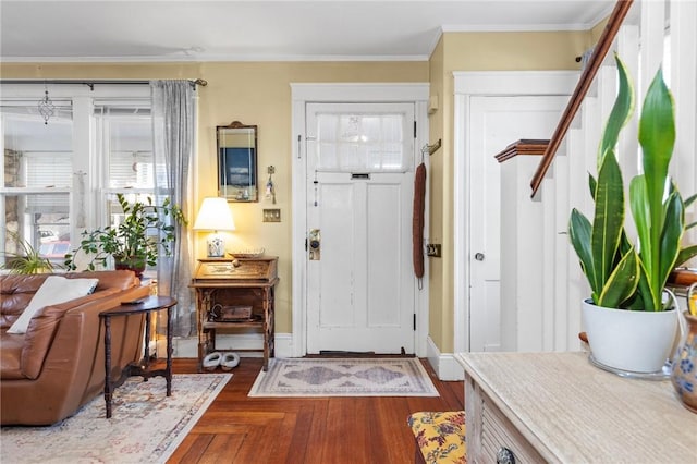 entrance foyer featuring crown molding, parquet floors, and baseboards