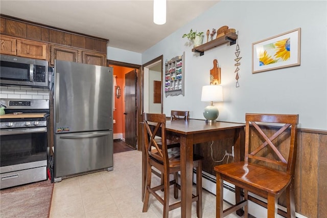 kitchen with light tile patterned flooring, backsplash, and stainless steel appliances