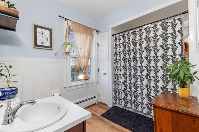 bathroom with vanity, a shower with shower curtain, wood finished floors, tile walls, and baseboard heating