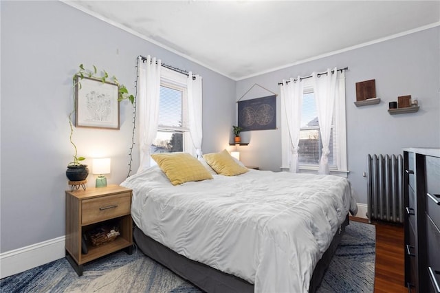 bedroom featuring ornamental molding, radiator heating unit, baseboards, and wood finished floors