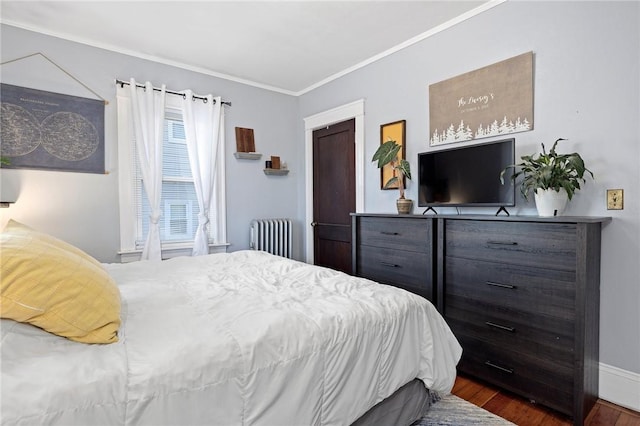 bedroom with radiator, wood finished floors, and ornamental molding