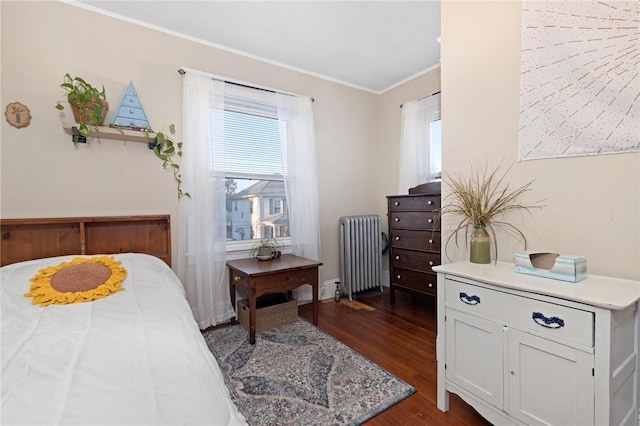 bedroom featuring dark wood finished floors, radiator, and ornamental molding