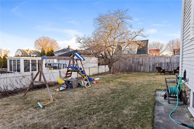 view of yard featuring a fenced backyard and a playground