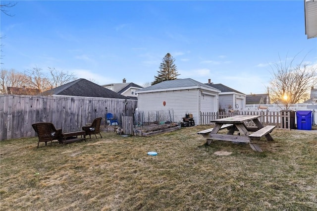 view of yard with an outdoor structure, a garden, and a fenced backyard