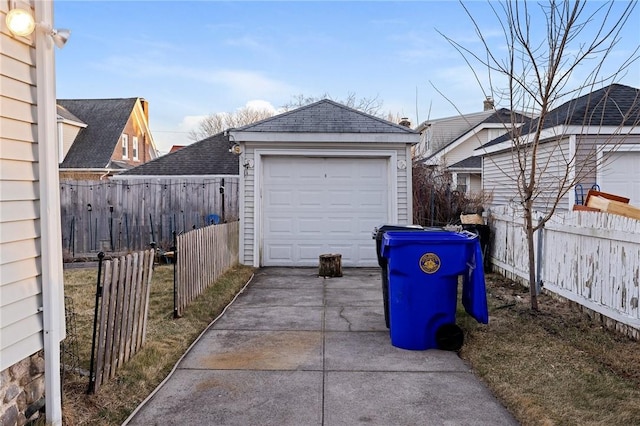 detached garage with driveway and fence