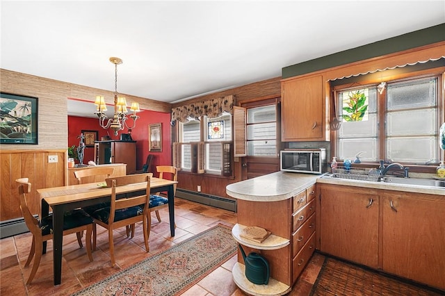 kitchen featuring stainless steel microwave, plenty of natural light, baseboard heating, and a peninsula