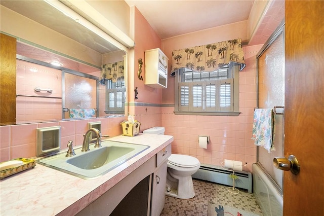 full bath featuring tile walls, bath / shower combo with glass door, toilet, vanity, and a baseboard radiator