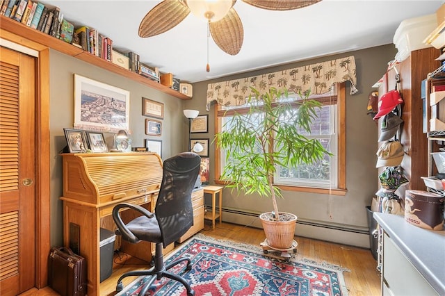 home office featuring light wood-type flooring, ceiling fan, and a baseboard radiator