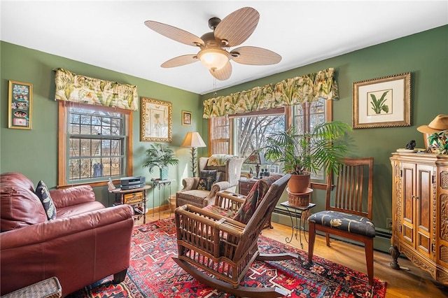 sitting room featuring plenty of natural light, a ceiling fan, and wood finished floors