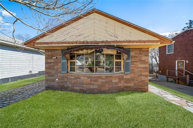 view of front of home with stone siding and a front lawn