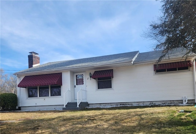 single story home featuring a shingled roof, a front lawn, entry steps, and a chimney