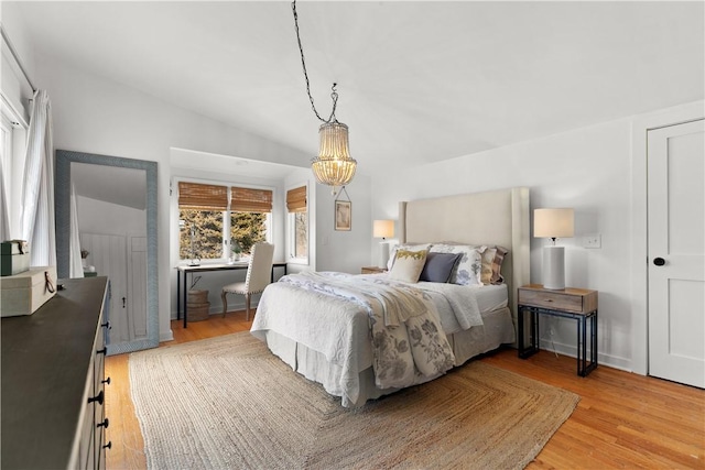 bedroom with lofted ceiling and light wood-style flooring