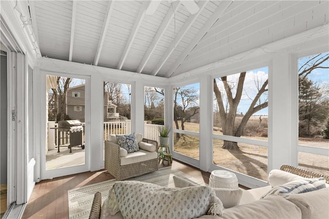 sunroom featuring lofted ceiling with beams