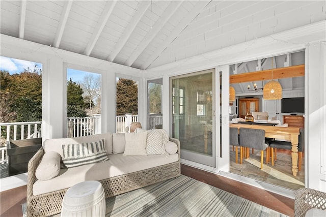 sunroom featuring lofted ceiling with beams, wood ceiling, and a healthy amount of sunlight