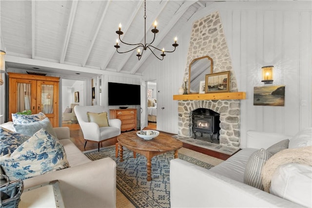 living room featuring an inviting chandelier, beamed ceiling, a wood stove, and high vaulted ceiling