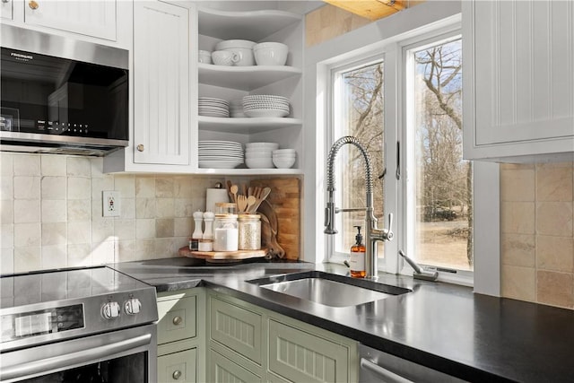 kitchen with dark countertops, appliances with stainless steel finishes, tasteful backsplash, and open shelves