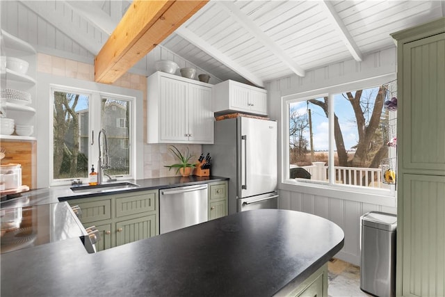 kitchen featuring lofted ceiling with beams, a sink, dark countertops, appliances with stainless steel finishes, and green cabinetry