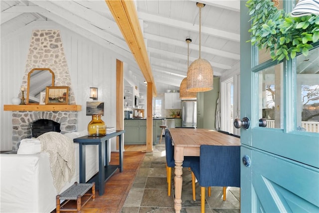 dining area featuring vaulted ceiling with beams