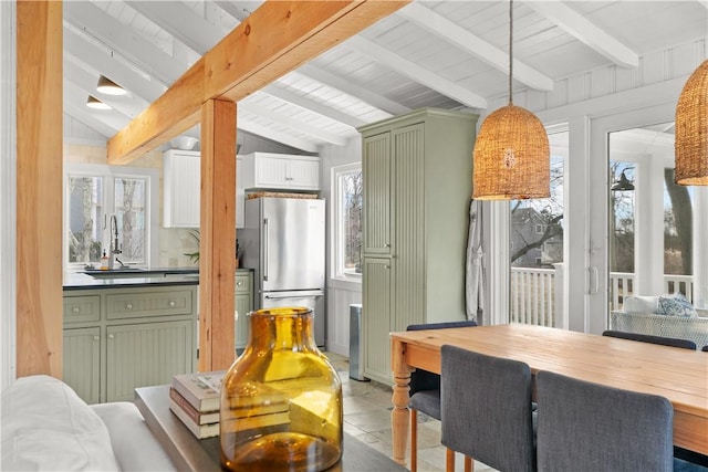 dining space with vaulted ceiling with beams