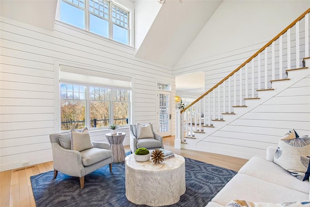 interior space with a healthy amount of sunlight, high vaulted ceiling, stairs, and wood finished floors