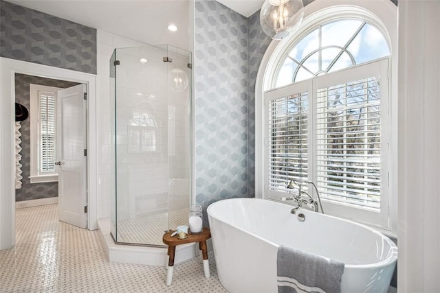 full bathroom with a healthy amount of sunlight, a stall shower, and wallpapered walls