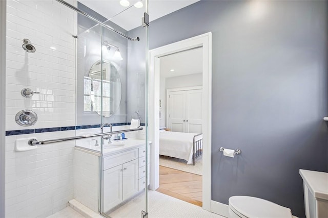 full bath featuring baseboards, vanity, toilet, and a shower stall