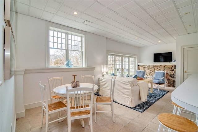 dining area featuring visible vents, baseboards, a stone fireplace, recessed lighting, and light tile patterned flooring