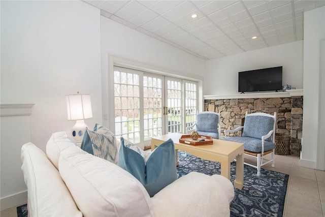 living area with recessed lighting, french doors, a fireplace, tile patterned flooring, and baseboards