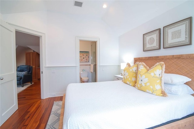 bedroom featuring visible vents, wood finished floors, and a wainscoted wall