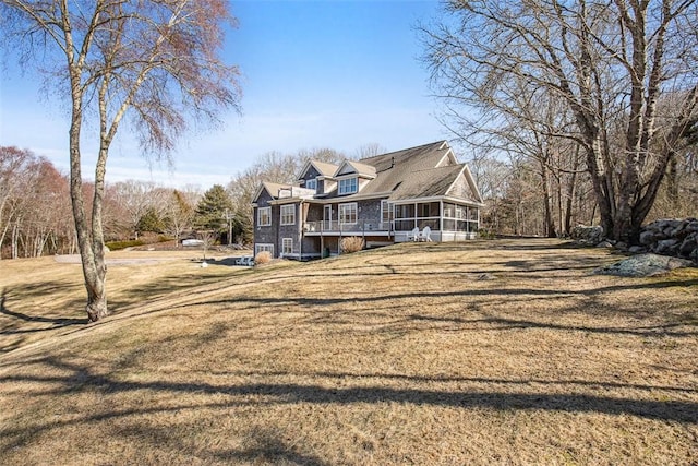 back of property with a yard and a sunroom