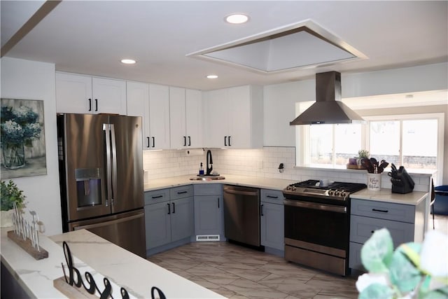 kitchen featuring extractor fan, light stone countertops, appliances with stainless steel finishes, marble finish floor, and a sink