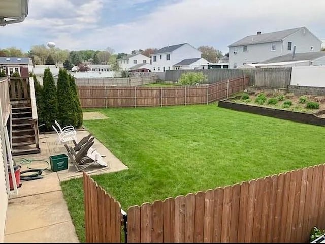 view of yard with a residential view, stairway, a patio, a fenced backyard, and a vegetable garden