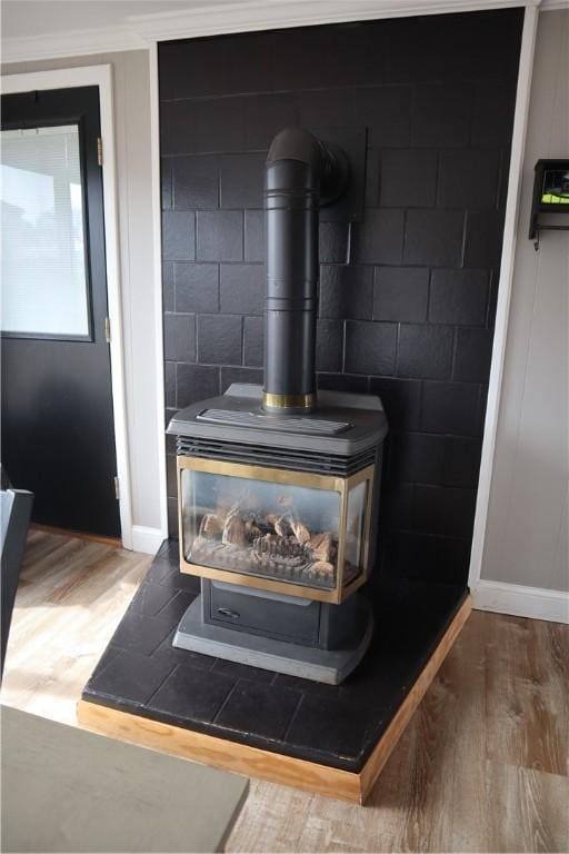 interior details featuring a wood stove, baseboards, and wood finished floors