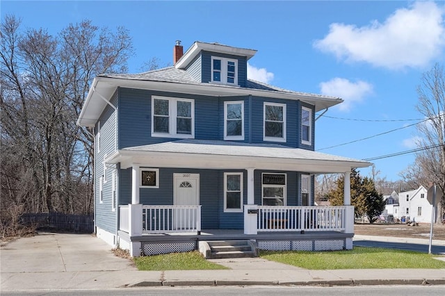 traditional style home featuring a porch and a chimney