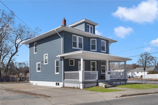 american foursquare style home featuring covered porch and a chimney