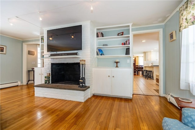 unfurnished living room with a brick fireplace, baseboard heating, wood-type flooring, and ornamental molding