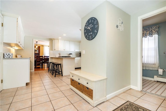 interior space with light tile patterned flooring, plenty of natural light, baseboards, and a baseboard radiator