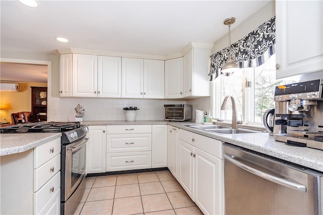 kitchen featuring a wall unit AC, light tile patterned floors, a sink, appliances with stainless steel finishes, and backsplash