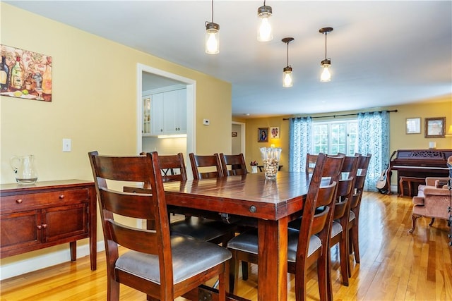 dining room featuring baseboards and light wood finished floors