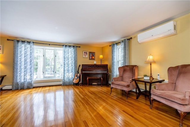 sitting room featuring hardwood / wood-style floors and a wall unit AC