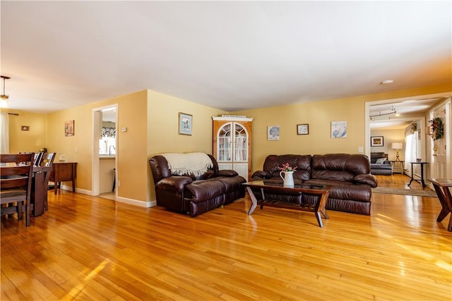 living room with light wood-type flooring and baseboards