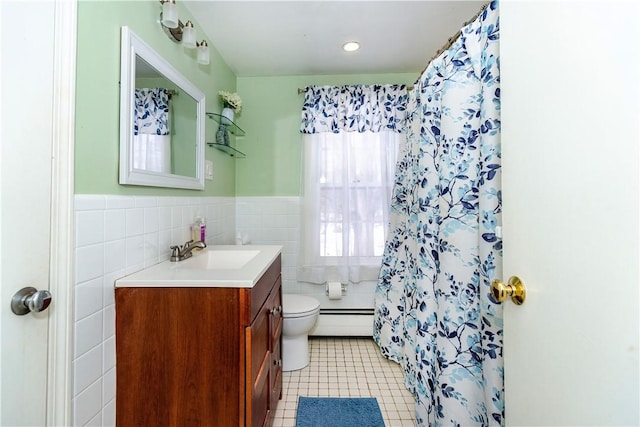 full bath with vanity, wainscoting, a baseboard heating unit, tile walls, and toilet