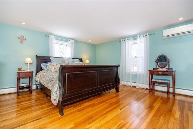 bedroom with recessed lighting, a wall mounted AC, and light wood-style floors