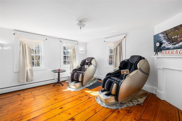 living area featuring a baseboard heating unit and wood-type flooring