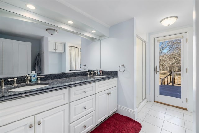 full bath with a stall shower, baseboards, double vanity, recessed lighting, and tile patterned flooring