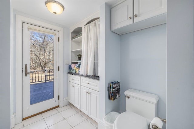 bathroom with tile patterned flooring, toilet, baseboards, and vanity